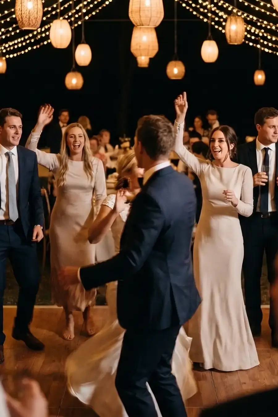 Guests dancing under festoon lights at a wedding reception