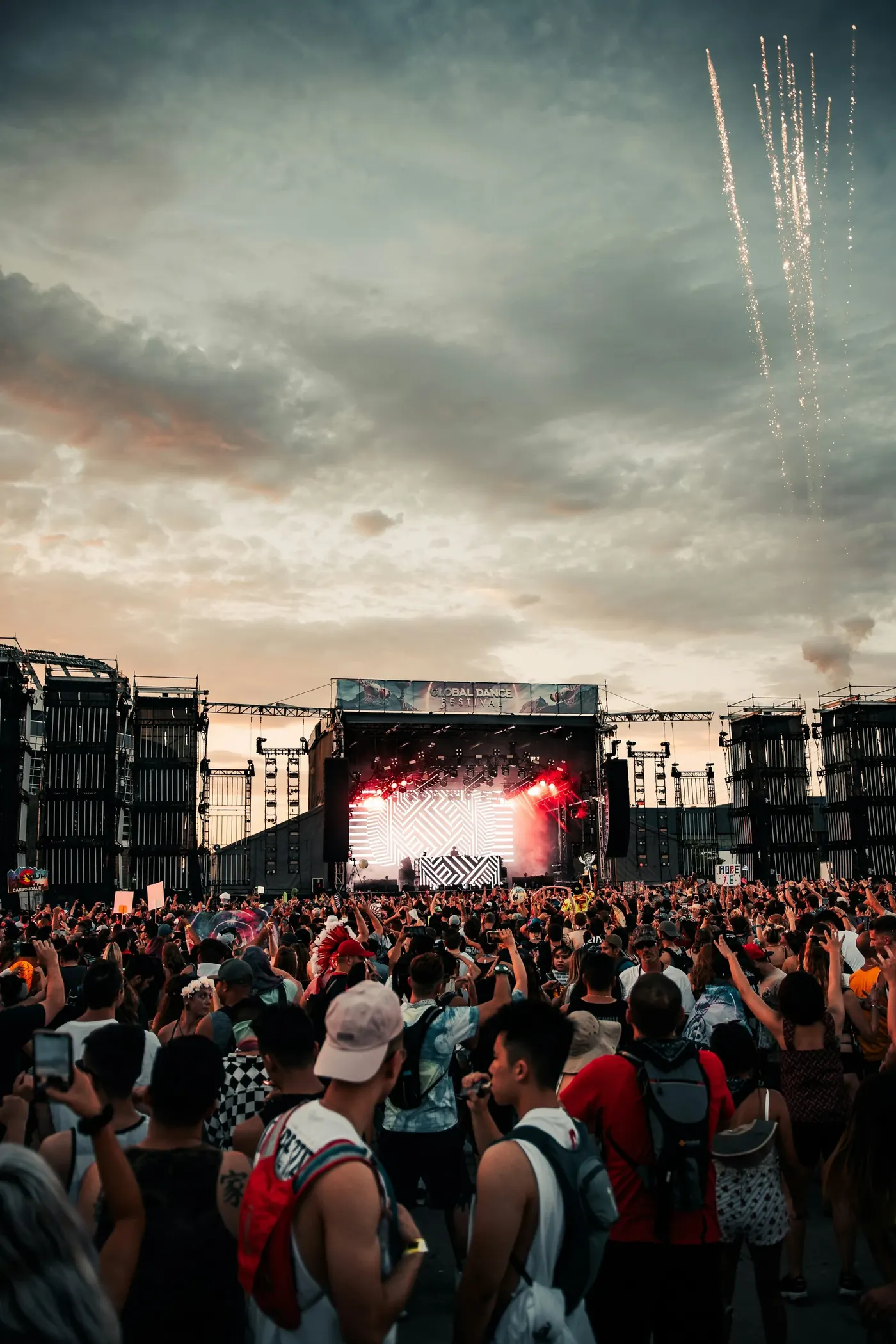 A dense festival crowd facing a brightly lit stage at night