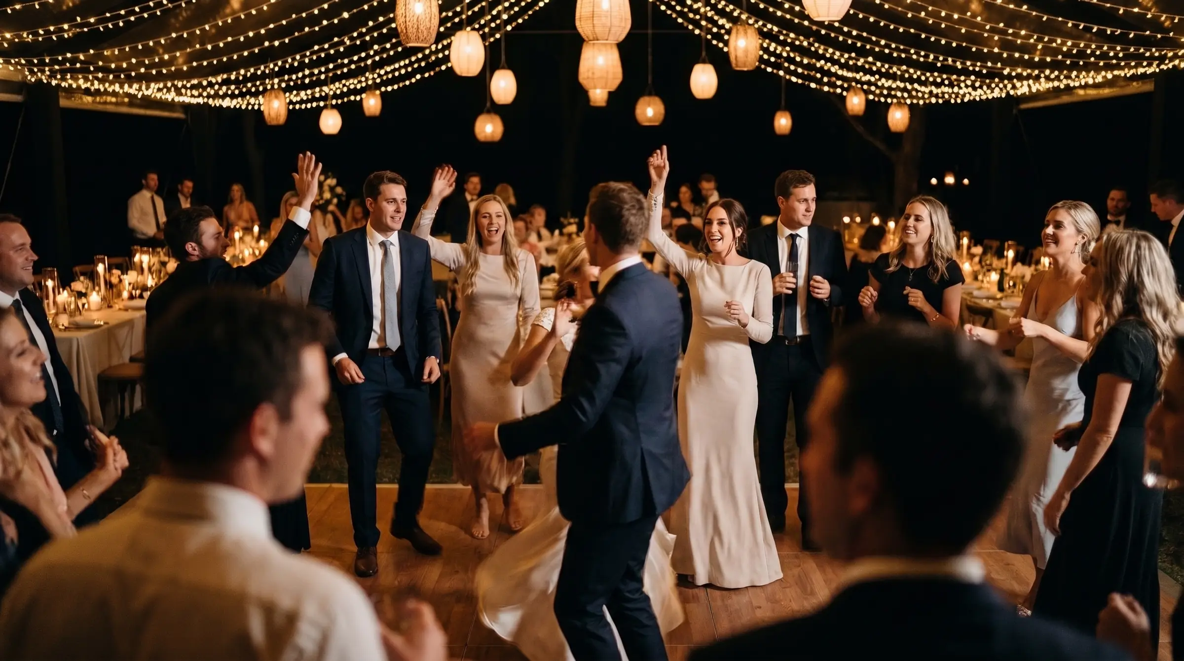 Guests dancing under festoon lights at a wedding reception